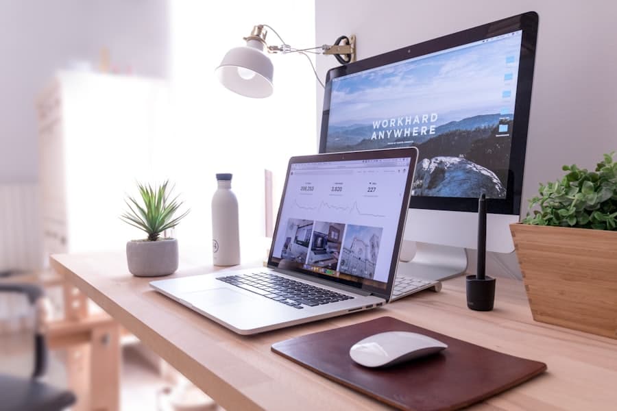 A tidy desk with a laptop and monitor showing a design in progress